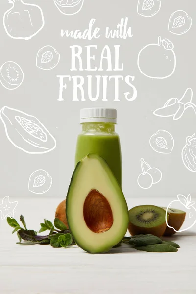 Smoothie desintoxicação verde com abacate, kiwi e hortelã na superfície de madeira branca, feito com inscrição de frutas reais — Fotografia de Stock