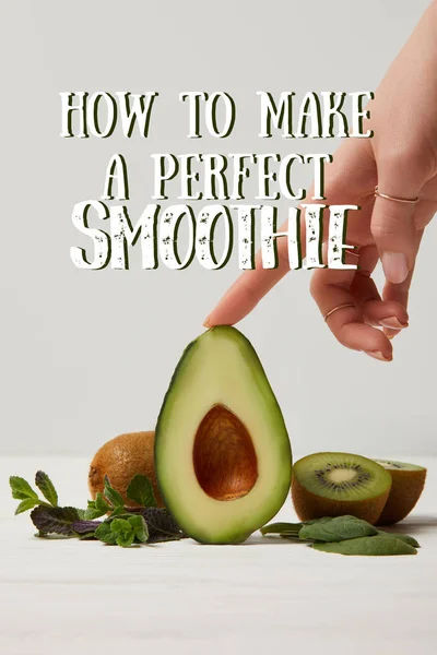 Cropped view of female hand with green avocado, kiwi and mint, how to make perfect smoothie inscription — Stock Photo