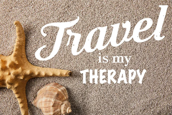 Top view of arranged sea star and seashell on sand, travel is my therapy inscription — Stock Photo