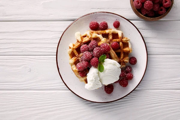 Tasty belgian waffles with raspberries and ice cream on white wooden table — Stock Photo