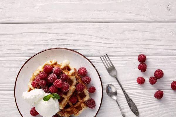 Waffles belgas deliciosos com framboesas e sorvete na mesa de madeira branca — Fotografia de Stock