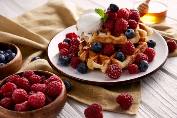 Frische belgische Waffeln mit Beeren und Eis auf weißem Holztisch — Stockfoto