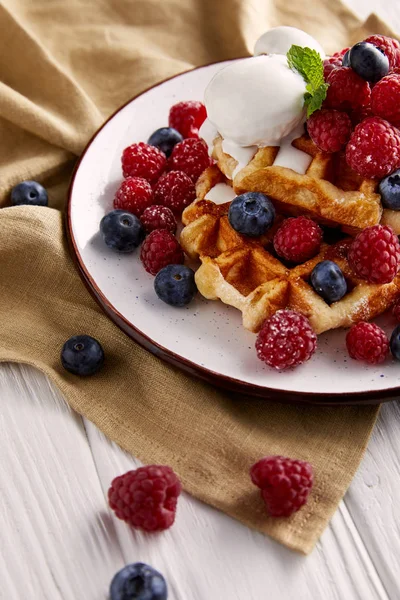 Fresh belgian waffles with berries and ice cream on white wooden table — Stock Photo