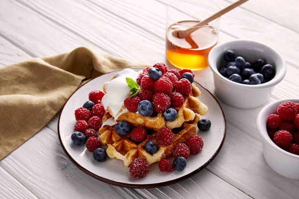 Waffles belgas saborosos com bagas e sorvete na mesa de madeira branca — Fotografia de Stock