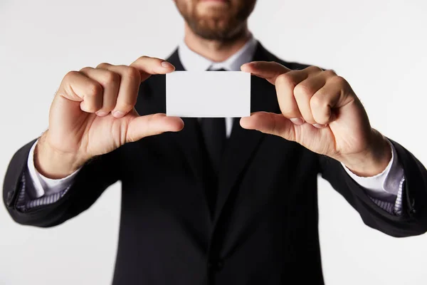 Vista parcial del hombre de negocios que presenta la tarjeta de visita en blanco aislado sobre fondo blanco - foto de stock