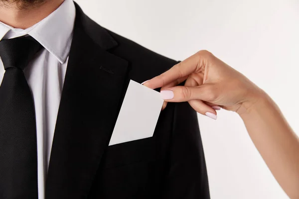 Imagen recortada de la mujer de negocios poniendo tarjeta de visita vacía en el bolsillo del hombre de negocios aislado sobre fondo blanco - foto de stock