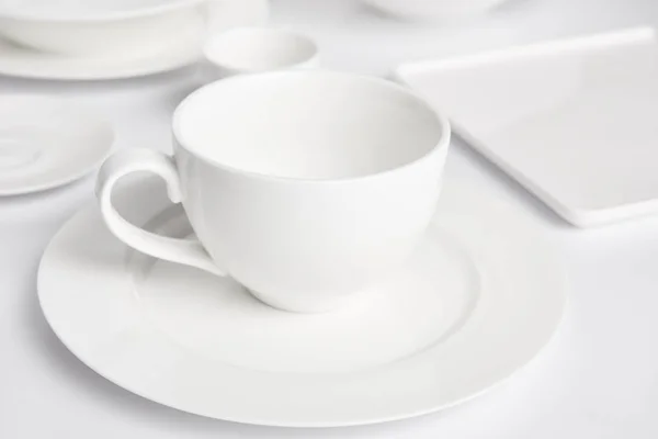 Selective focus of plates and bowl on white tabletop — Stock Photo