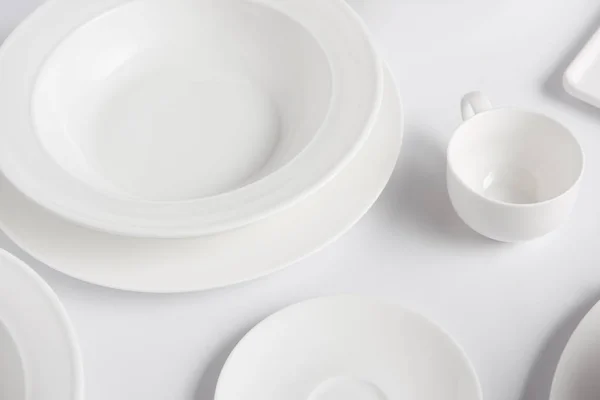 Selective focus of different plates and cup on white table — Stock Photo