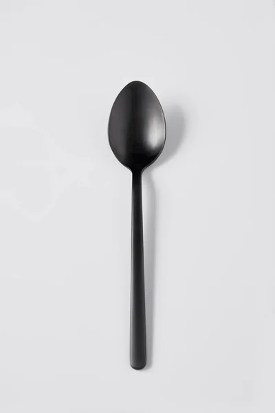 Vista elevada de la cuchara negra sobre fondo blanco, concepto minimalista - foto de stock