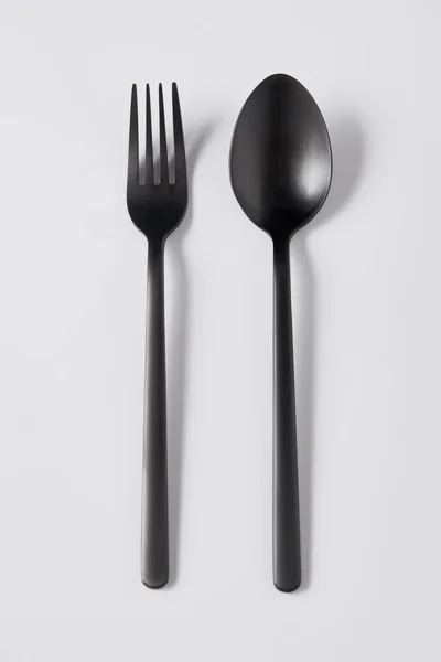 Top view of black fork and spoon on white background, minimalistic concept — Stock Photo