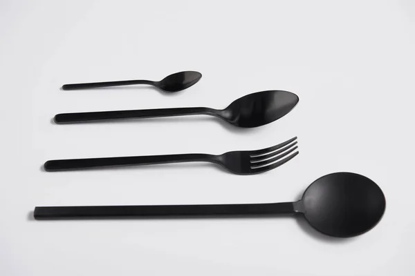 Close up view of arranged salad spoon, fork and spoons on white table, minimalistic concept — Stock Photo