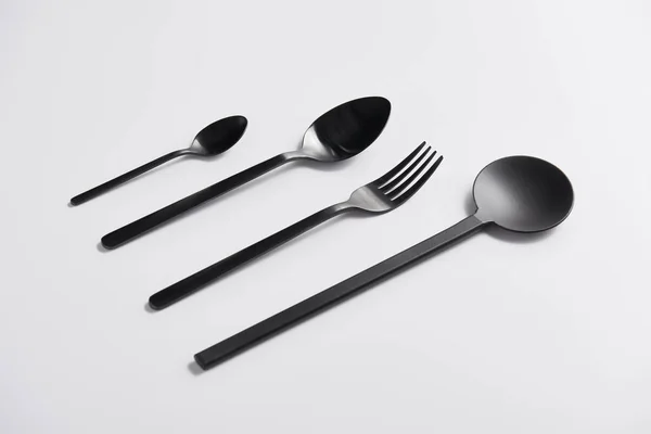 Imagen de cerca de cuchara de ensalada arreglada, tenedor y cucharas en la mesa blanca - foto de stock