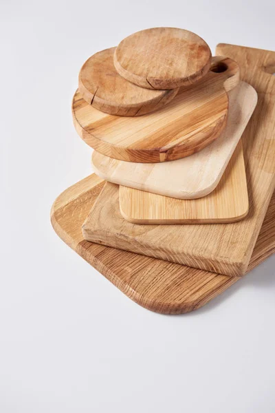 Selective focus of stack of different wooden cutting boards on white table — Stock Photo