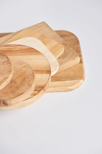 Close up shot of stack of different wooden cutting boards on white table — Stock Photo