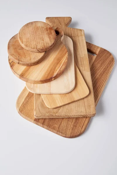 High angle view of stack of different wooden cutting boards on white table — Stock Photo