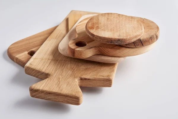 Selective focus of stack of different wooden cutting boards on white table — Stock Photo