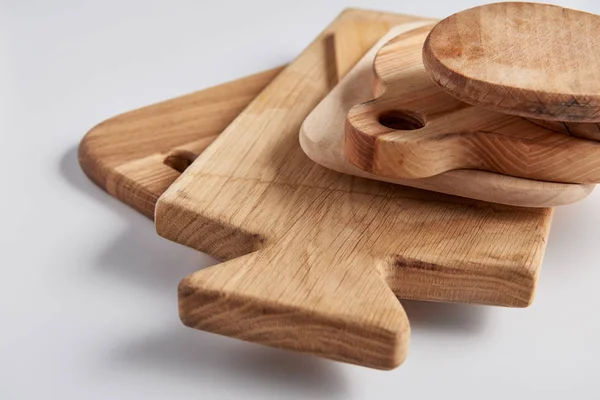 Close up view of stack of different wooden cutting boards on white table — Stock Photo