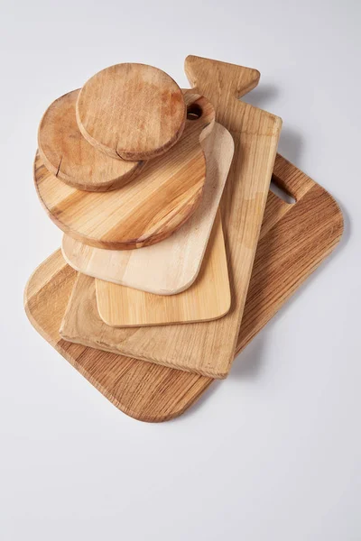 Top view of stack of different wooden cutting boards on white table — Stock Photo