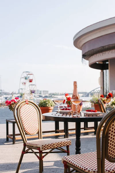 Acogedora cafetería al aire libre con champán y postres dulces en la mesa - foto de stock