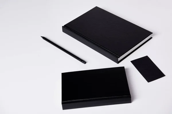Крупным планом черные блокноты на белой поверхности для макета — стоковое фото