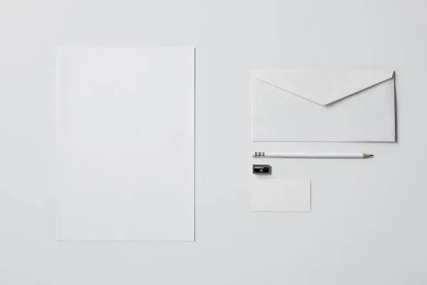 Top view of business mockup with paper supplies and pencil on white surface for mockup — Stock Photo