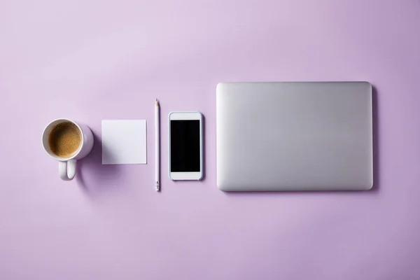 Vue de dessus de divers objets de travail d'affaires disposés en rangée sur la table rose pour la maquette — Photo de stock