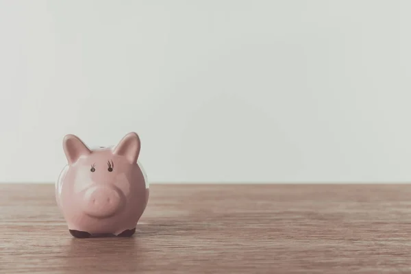 Small pink piggy bank on wooden table, saving concept — Stock Photo