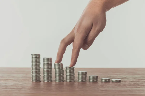 Zugeschnittenes Bild eines Mannes, der mit den Fingern auf Stapeln von Münzen auf dem Tisch geht, Sparkonzept — Stockfoto