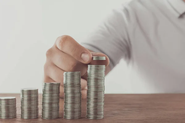 Cropped image of man stacking coins on wooden surface, saving concept — Stock Photo