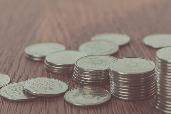 Close up of stacks of coins and scattered ukrainian coins on tabletop, saving concept — Stock Photo