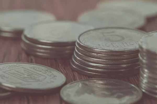 Close up of stacks of coins and scattered ukrainian coins on wooden table, saving concept — Stock Photo