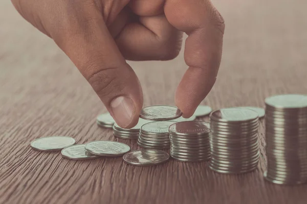 Cropped image of man stacking coins on wooden surface, saving concept — Stock Photo