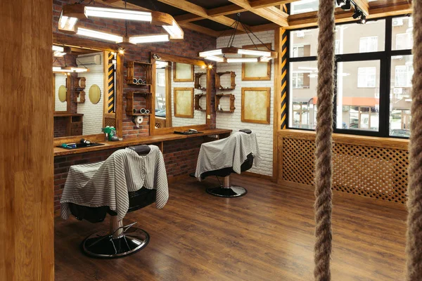 Cadeiras vazias e espelhos no interior barbearia moderna — Fotografia de Stock