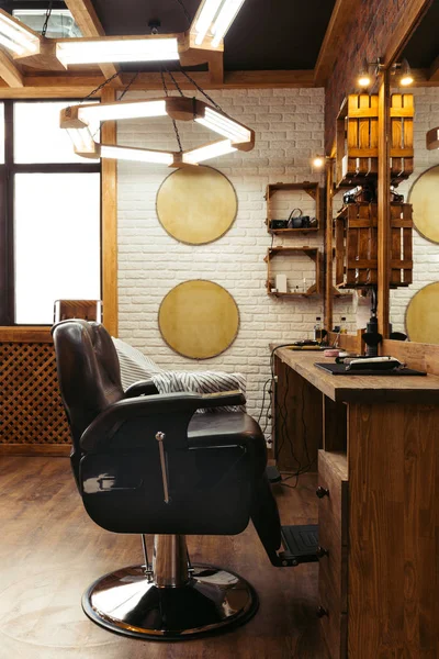 Empty chair, mirrors and lamps in modern barbershop interior — Stock Photo