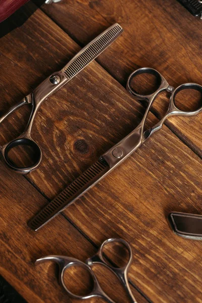 High angle view of professional scissors on wooden surface in barbershop — Stock Photo