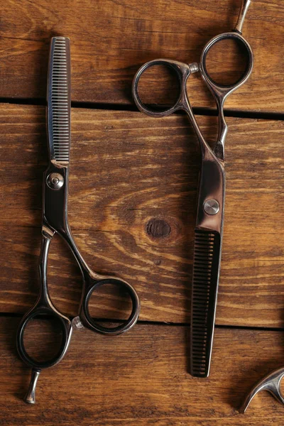 Vista superior da tesoura profissional na superfície de madeira na barbearia — Fotografia de Stock