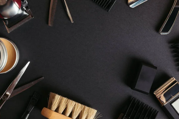 Вид зверху різних професійних перукарських інструментів на чорному тлі — стокове фото