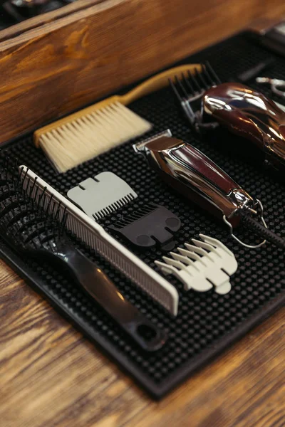 Close-up view of various professional barber tools on wooden shelf in barbershop — Stock Photo