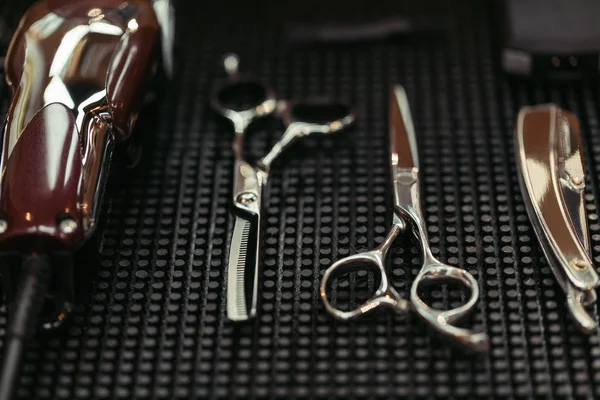 Vista de perto da tesoura, cortador elétrico e navalha reta na barbearia — Fotografia de Stock