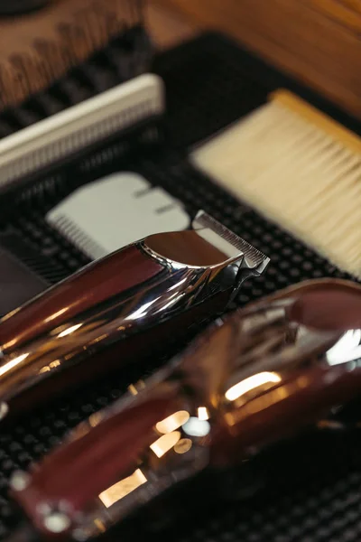 Close-up view of electric clippers and various hair combs in barbershop — Stock Photo