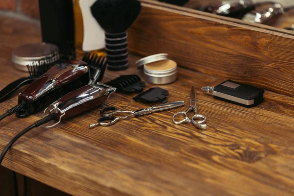 Close-up view of various barber tools on wooden shelf in barbershop — Stock Photo