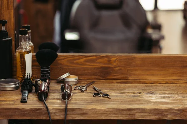 Barber tools on wooden shelf and mirror in barbershop — Stock Photo