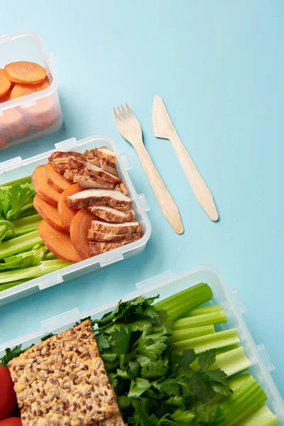 Close up view of arrangement of cutlery and food containers with fresh healthy vegetables and meat background — Stock Photo