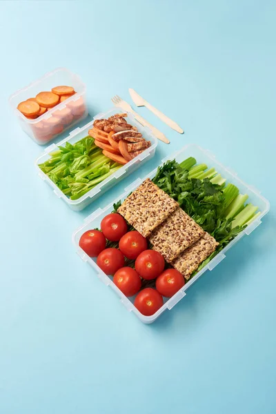 Close up view of arrangement of food containers with fresh vegetables, meat and cookies background — Stock Photo