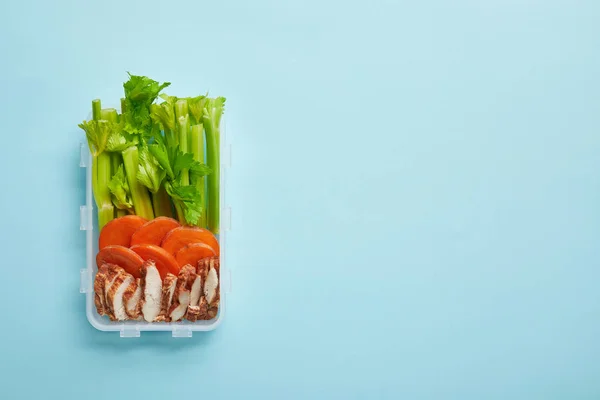 Top view of food container full of healthy meal isolated on blue — Stock Photo