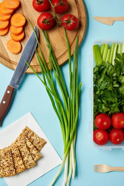 Pose plate avec couteau et composition saine des aliments isolés sur bleu — Photo de stock
