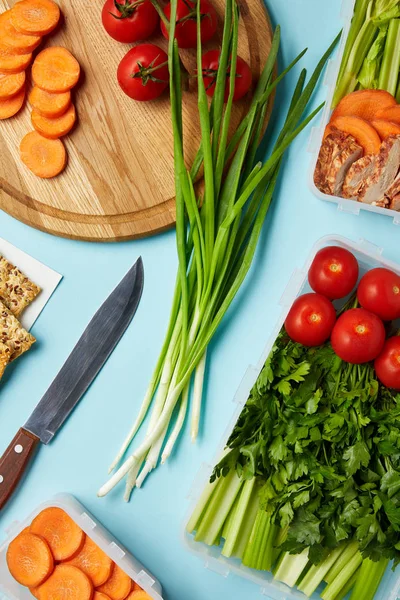 Tendido plano con cuchillo y composición de alimentos saludables aislados en azul - foto de stock