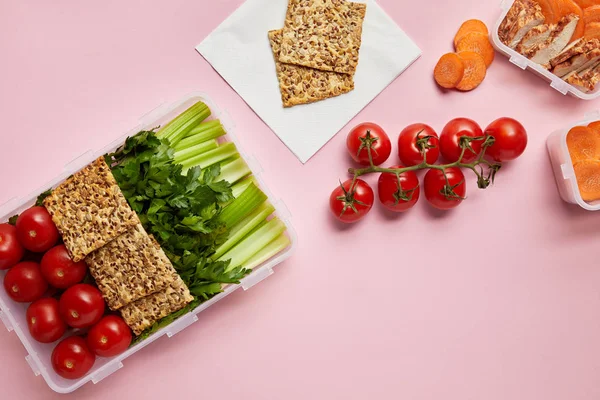 Yacía plana con alimentos saludables dispuestos en recipientes de alimentos aislados en rosa - foto de stock