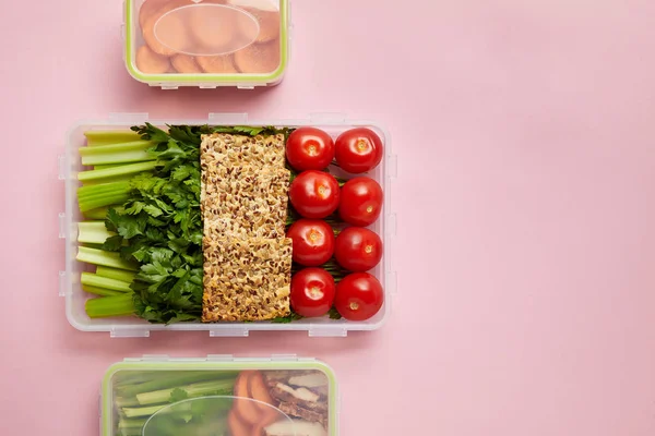 Tendido plano con verduras frescas y galletas dispuestas en recipientes de alimentos aislados en rosa — Stock Photo