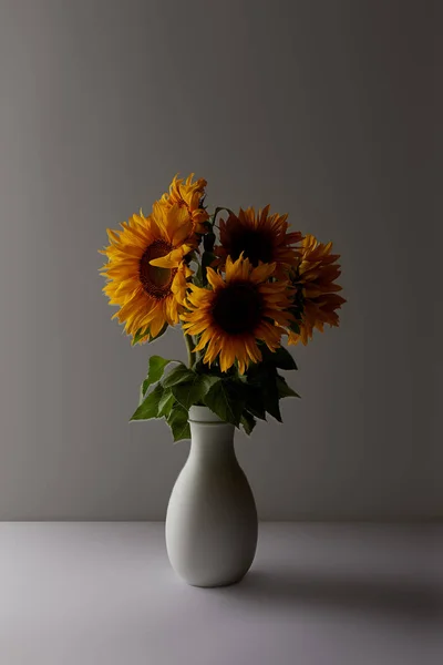 Bouquet décoratif de tournesols jaunes en vase, sur fond gris — Photo de stock